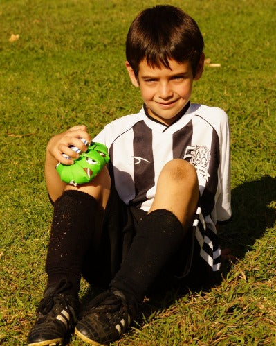 young soccer player treating a sore knee with ice bag
